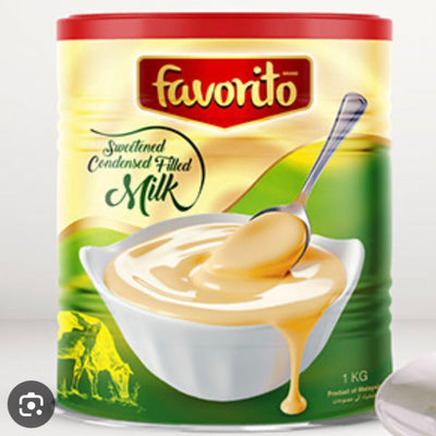 Can of Favorito sweetened condensed milk with a spoonful of milk on a white background
