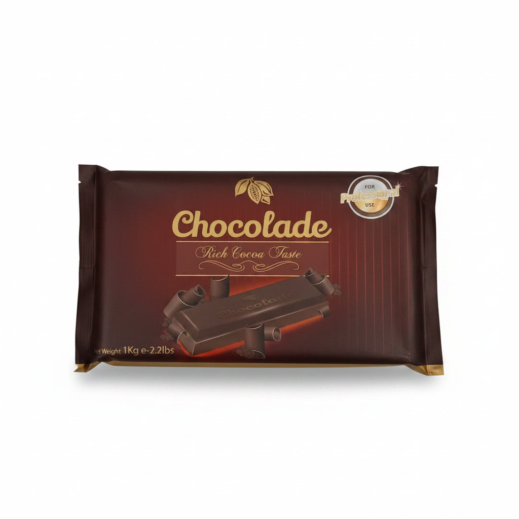 Hand holding a chocolate packaging with 'Chocolade' branding on a tiled floor.