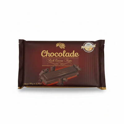 Hand holding a chocolate packaging with 'Chocolade' branding on a tiled floor.