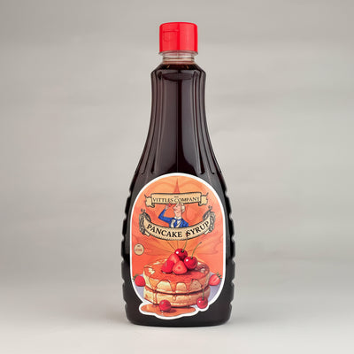 Bottle of pancake syrup with a red cap on a gray background