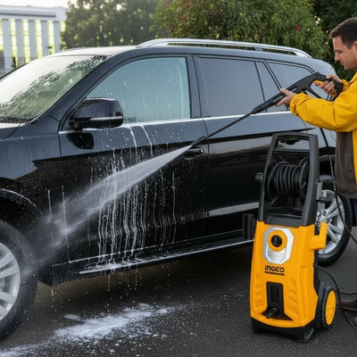 Person using a pressure washer to clean a yellow car outdoors.