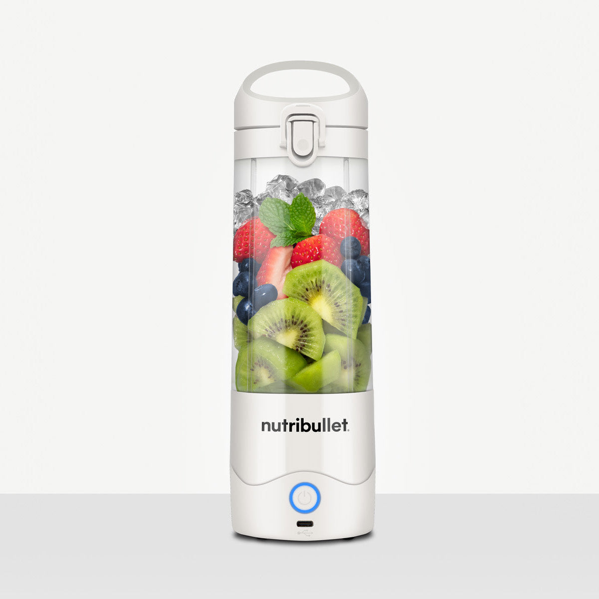 Nutribullet blender with fruits inside on a white background