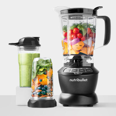 Nutribullet blender with various ingredients inside on a white background