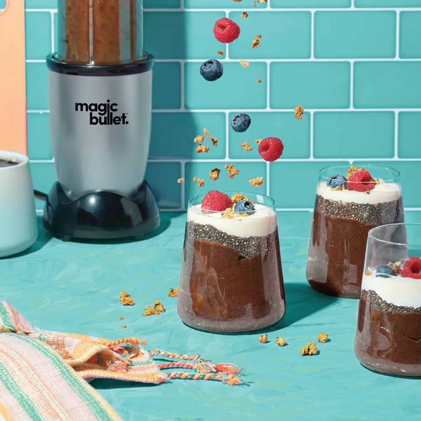 Magic Bullet blender with dessert cups on a blue tiled background