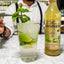 Mojito cocktail with lime and mint garnish next to a bottle of Monin Mojito Mix.