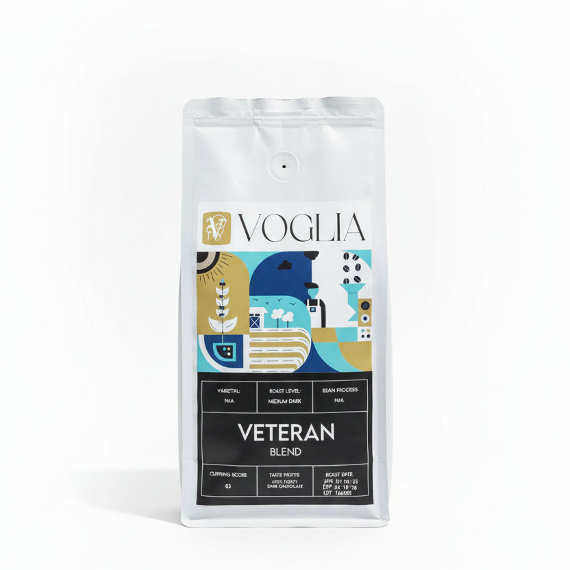 Voglia Veteran Blend coffee bag on a wooden surface with a blurred background