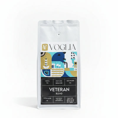 Voglia Veteran Blend coffee bag on a wooden surface with a blurred background