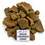 A pile of dark brown, textured pressed cake pieces with a small white label reading 'NEEM PRESSED CAKE' in English and Urdu, set against a solid white background.